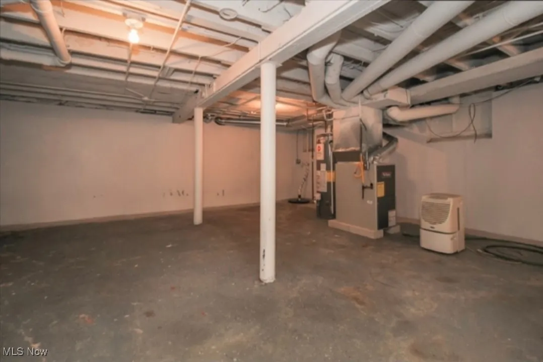 Unfinished basement featuring heating unit