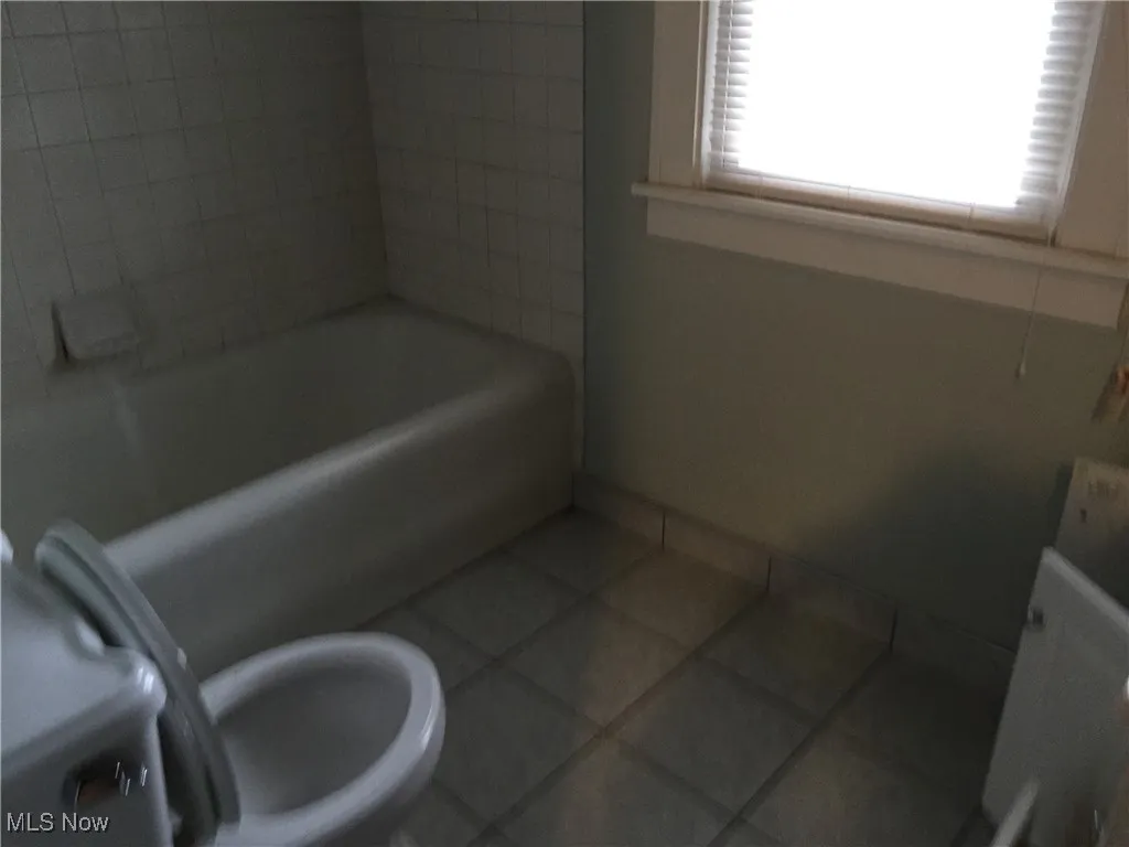 Bathroom featuring tile patterned flooring and  shower combination