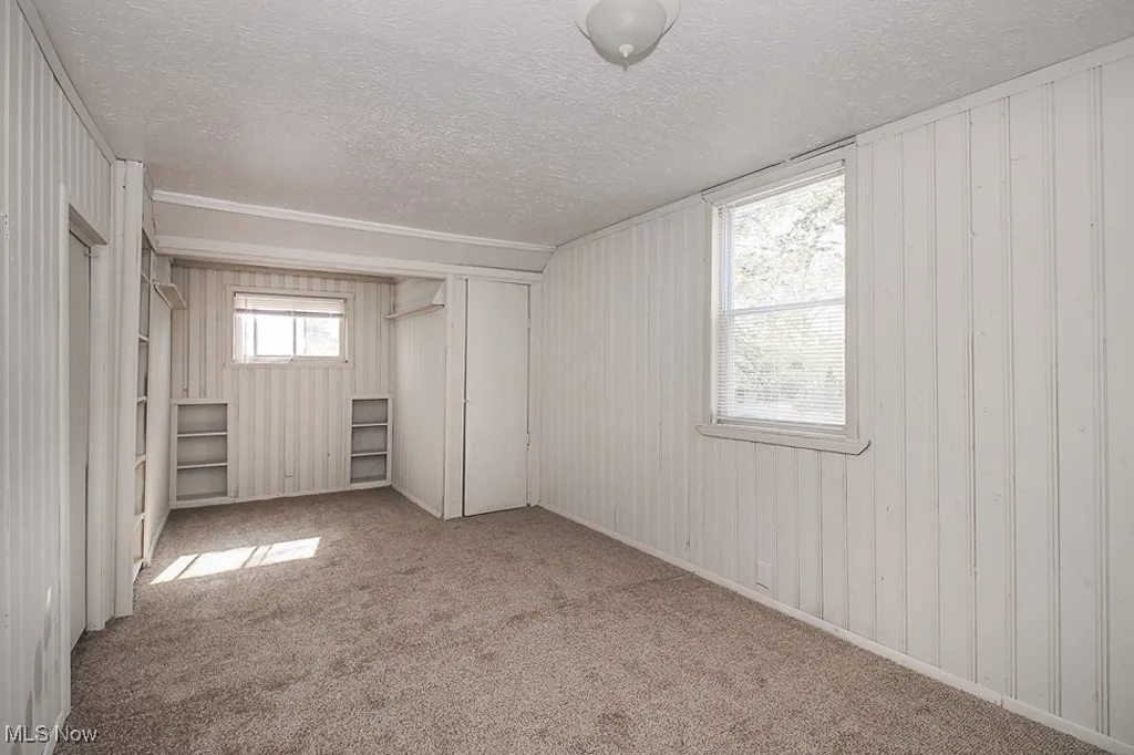 Unfurnished bedroom with a textured ceiling, carpet floors, and a closet