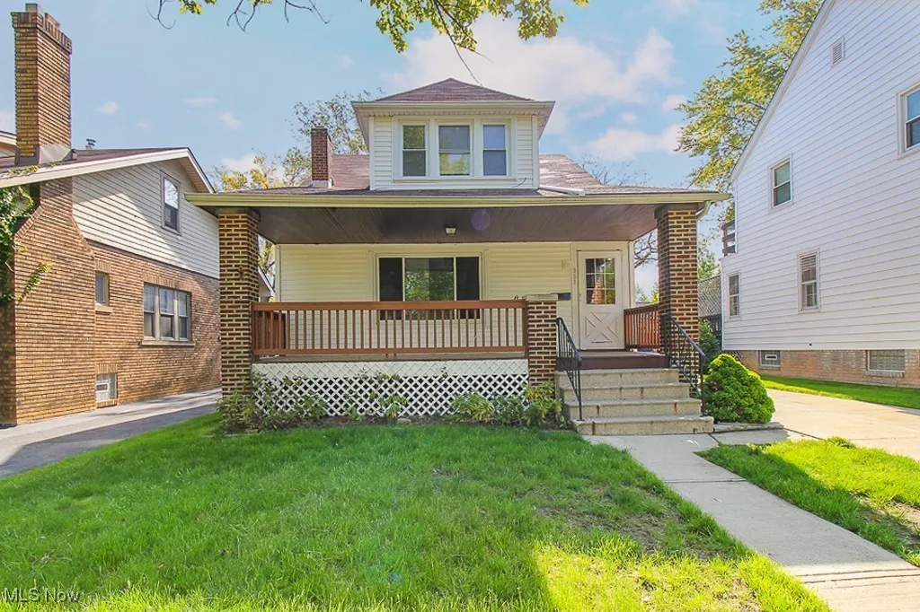 View of front facade featuring a porch, a front lawn, and a chimney