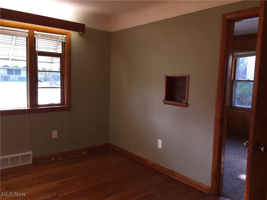 Spare room with dark wood finished floors and baseboards