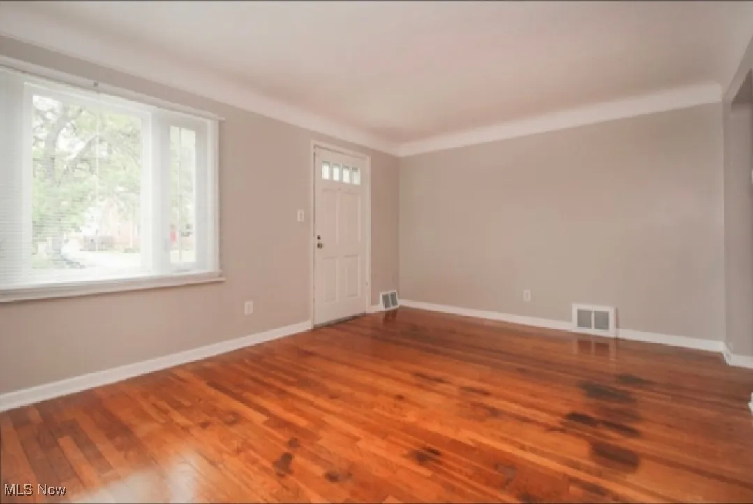 Foyer entrance with wood finished floors and baseboards