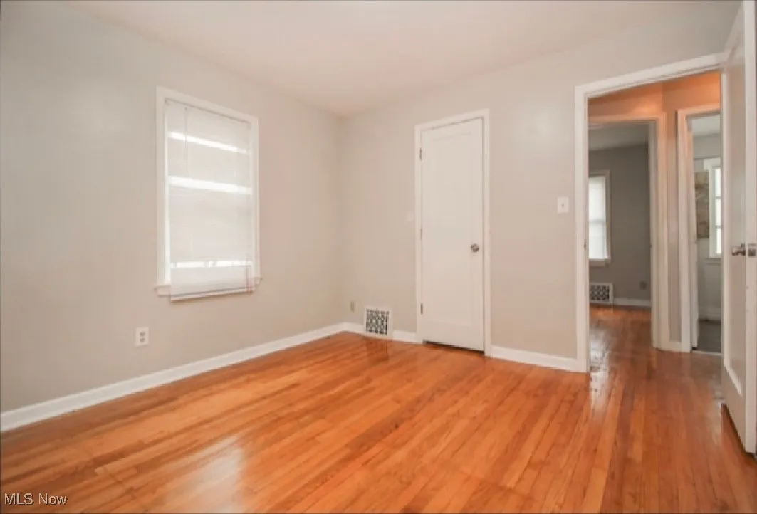 Unfurnished bedroom featuring multiple windows and light wood-style floors