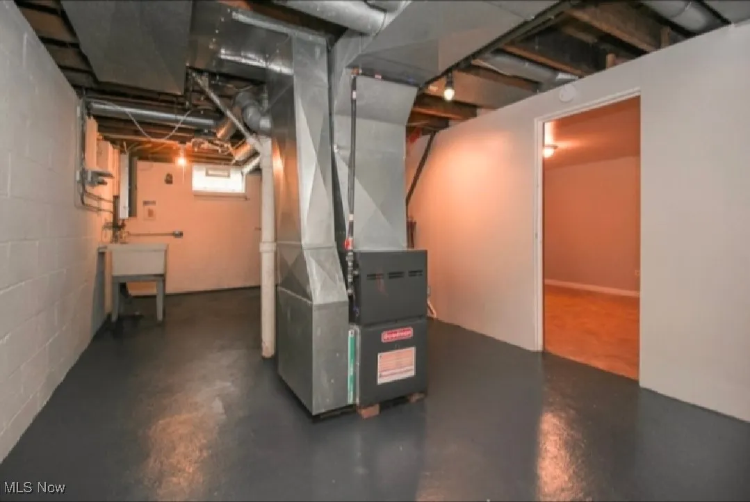 Basement featuring heating unit and concrete block wall