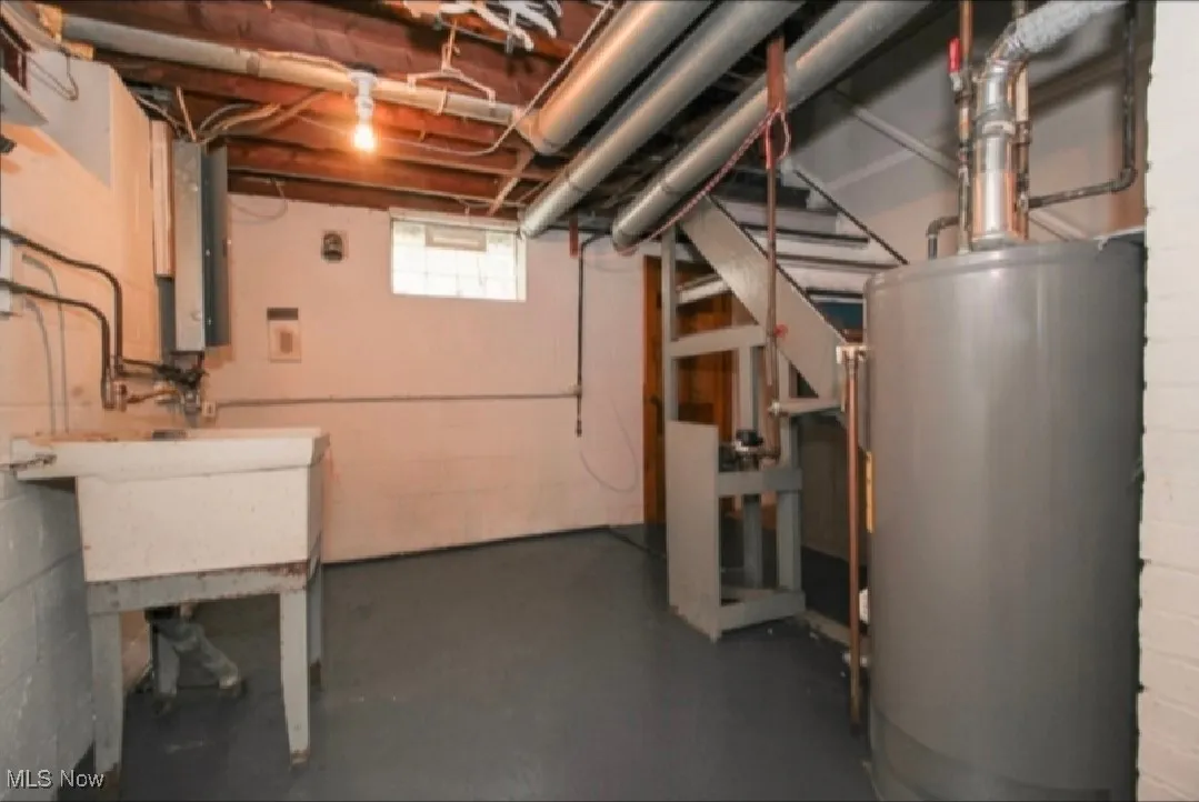 Basement featuring water heater and a sink