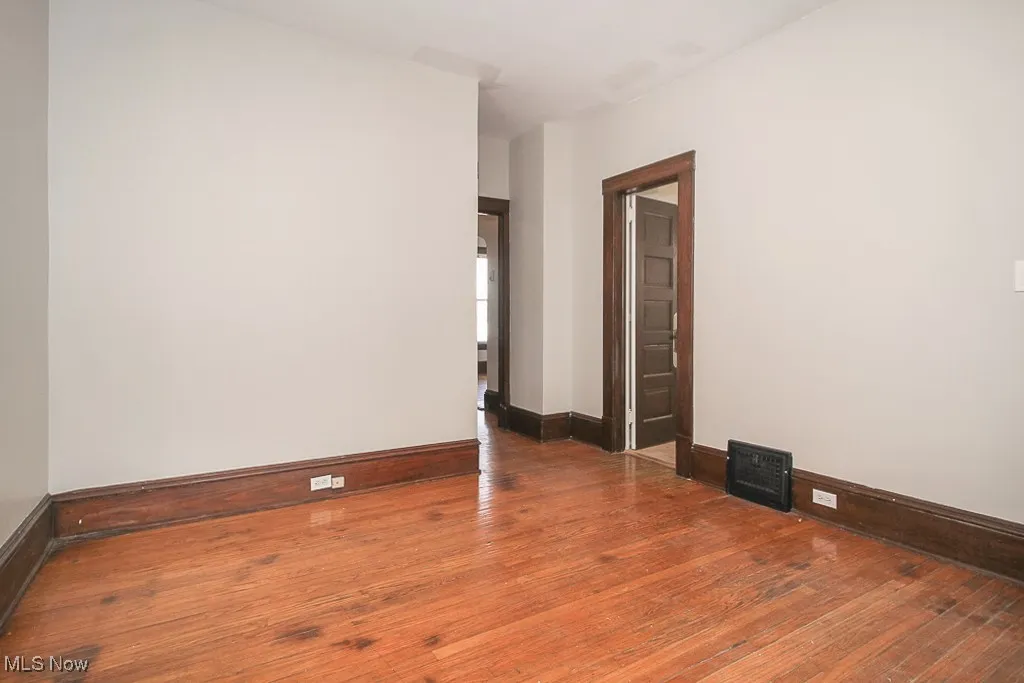 Spare room with wood-type flooring and baseboards