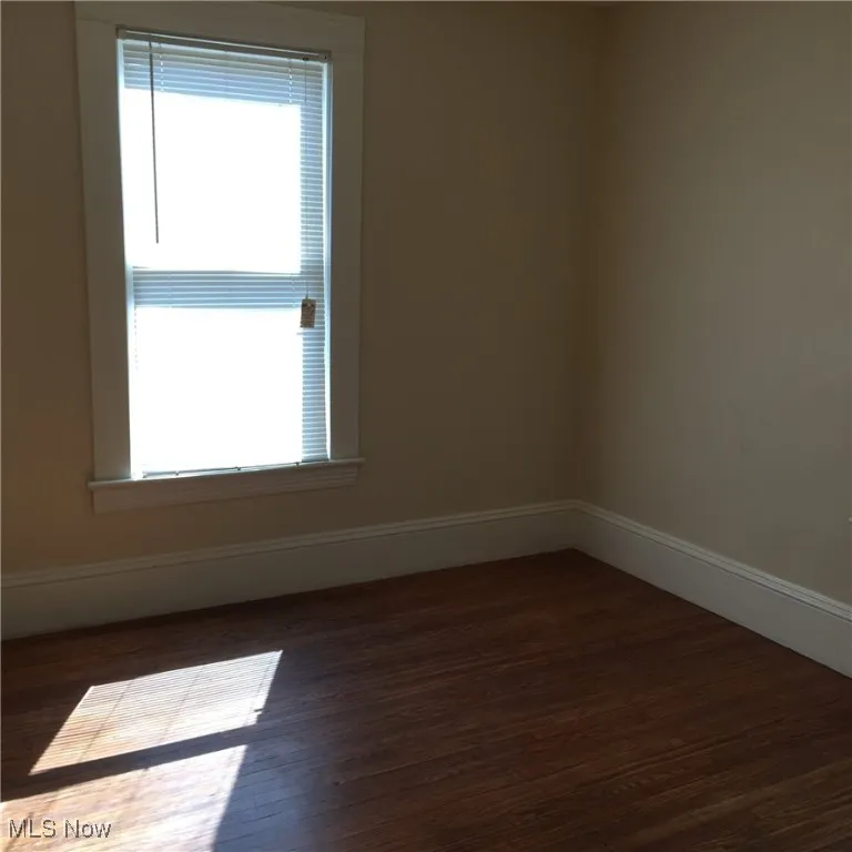 Spare room with healthy amount of natural light and wood finished floors