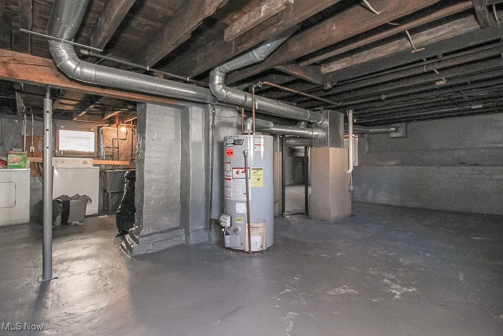 Below grade area featuring gas water heater, separate washer and dryer, and heating unit