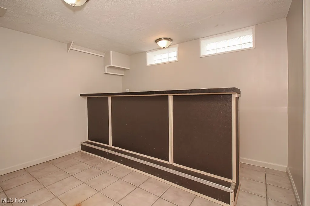Bar area with tile patterned flooring and a textured ceiling