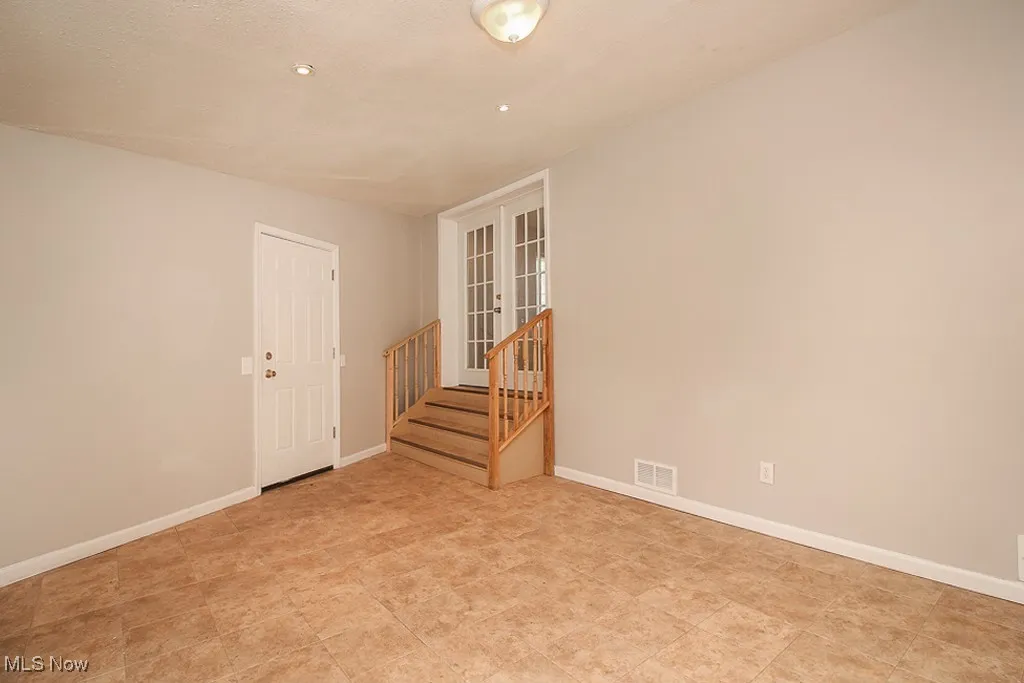 Empty room with stairway and recessed lighting