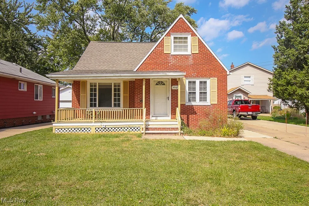 View of front of home with brick siding, a porch, a front lawn, roof with shingles, and driveway