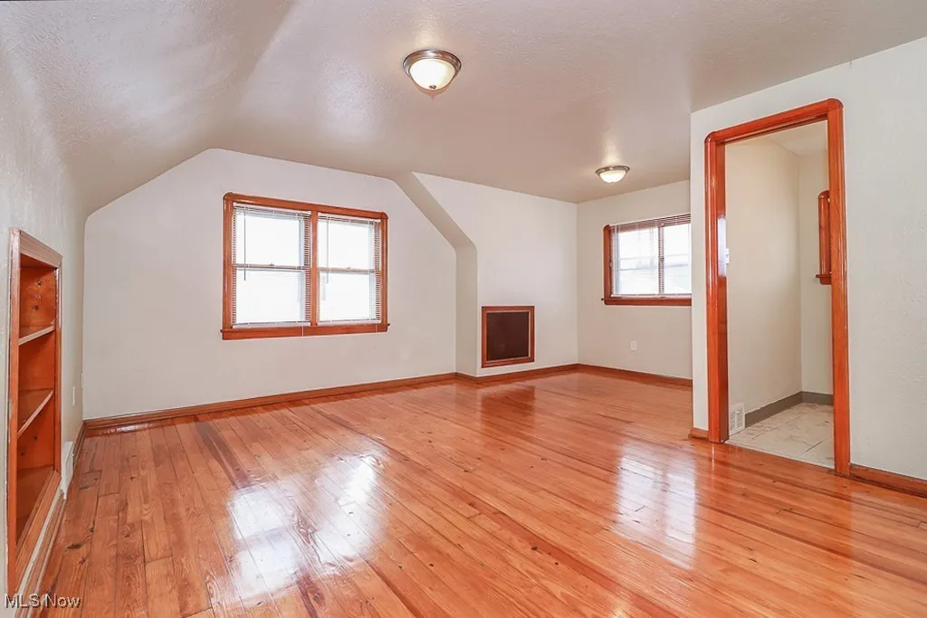 Bonus room featuring light wood-style flooring and vaulted ceiling