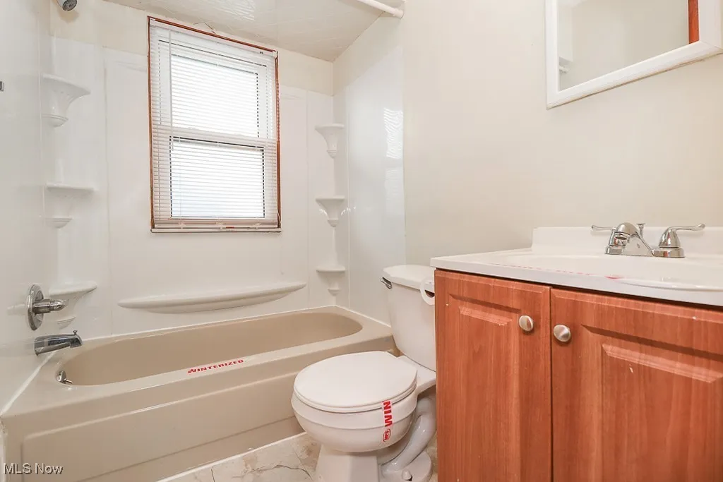 Full bathroom with vanity, tub / shower combination, and marble look tiles