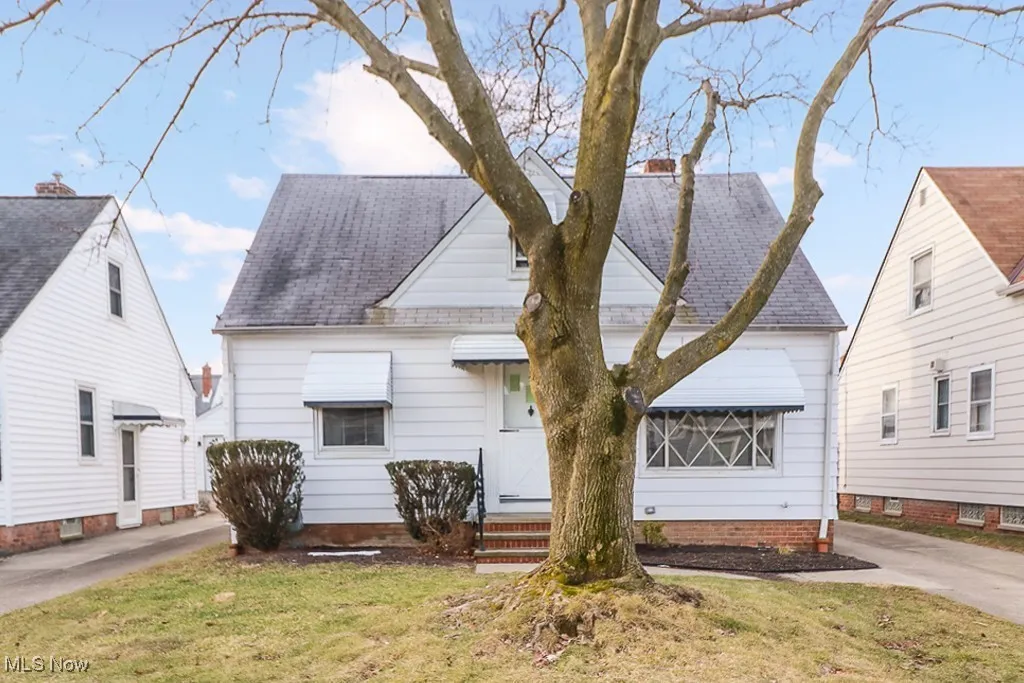 View of front of property with a shingled roof and a front yard