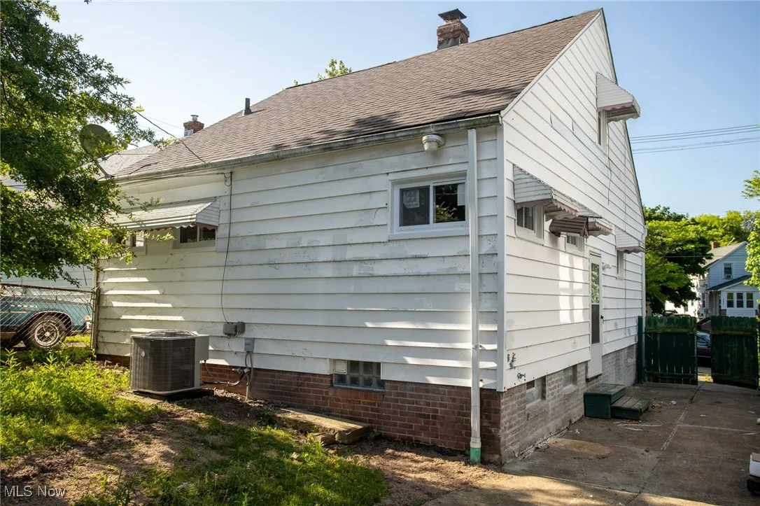 View of property exterior with a chimney and a shingled roof