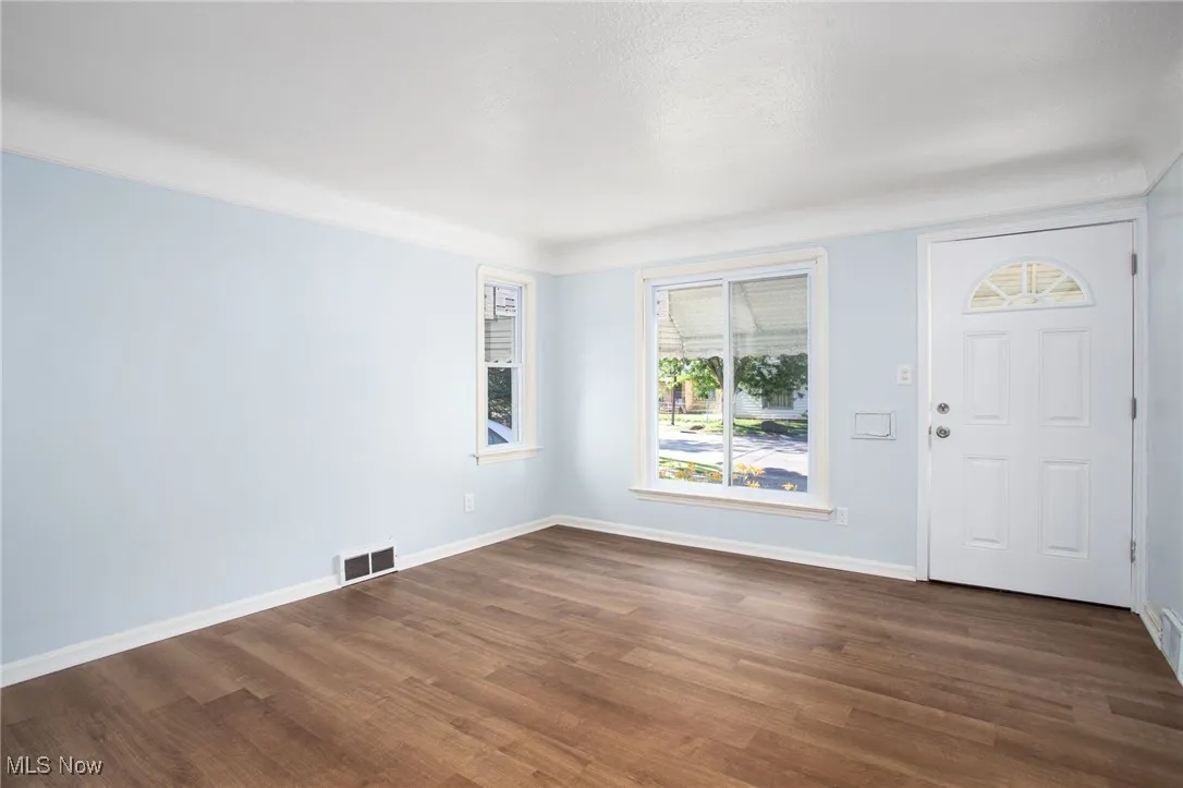 Entrance foyer featuring dark wood-type flooring and baseboards