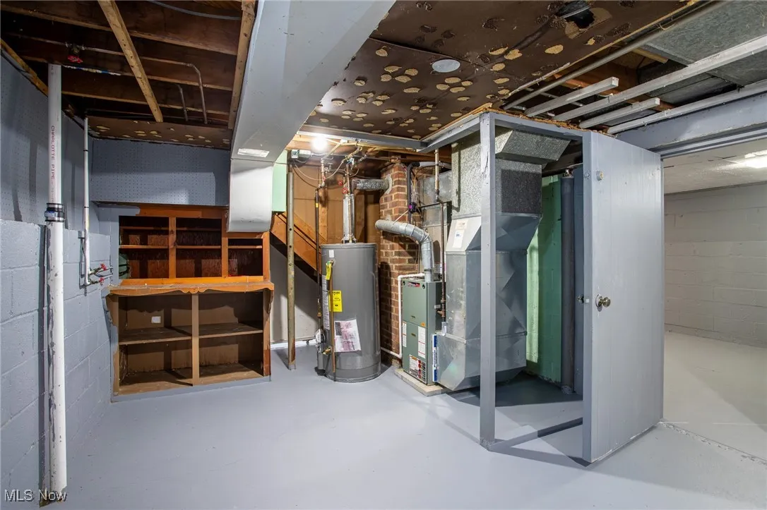Unfinished basement featuring water heater and heating unit