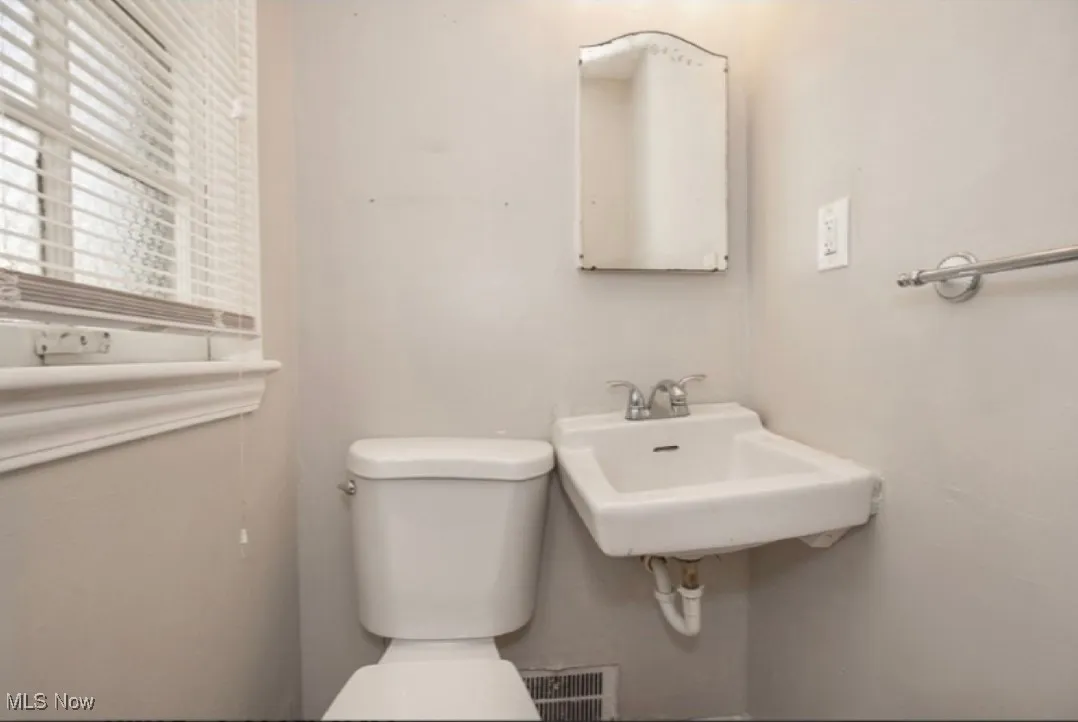 Half bath featuring toilet and a sink