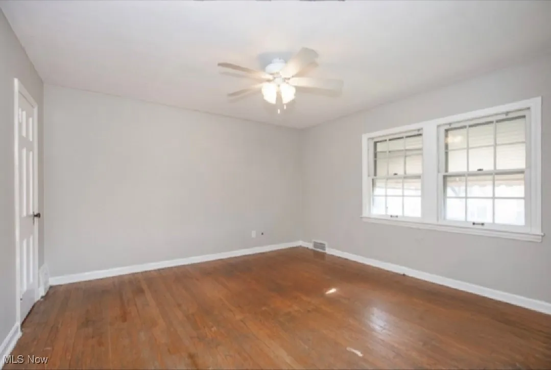 Spare room with a ceiling fan and dark wood finished floors
