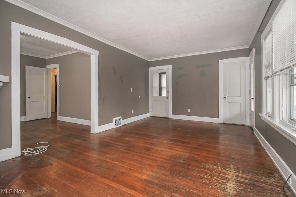 Spare room featuring hardwood / wood-style flooring and crown molding