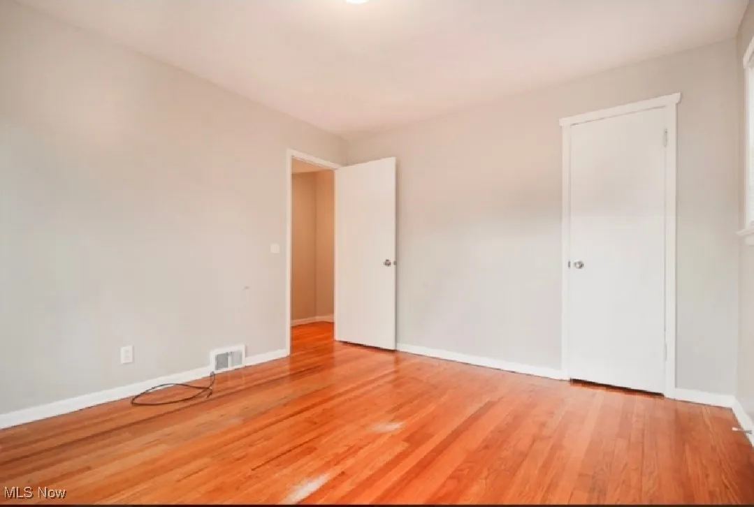 Unfurnished bedroom featuring wood finished floors and baseboards