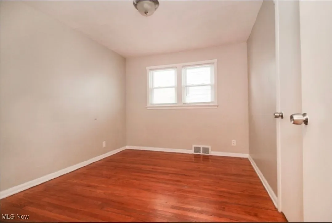 Empty room featuring wood finished floors and baseboards