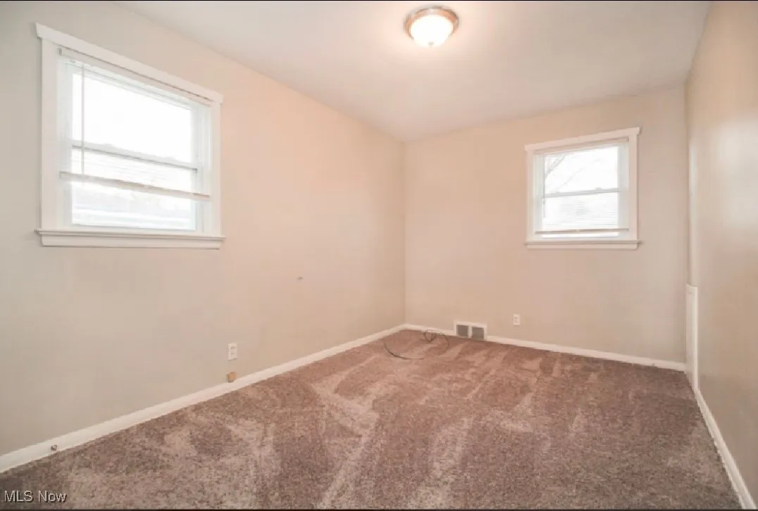 Carpeted empty room with baseboards