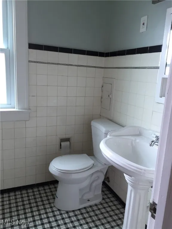 Bathroom with tile walls and toilet