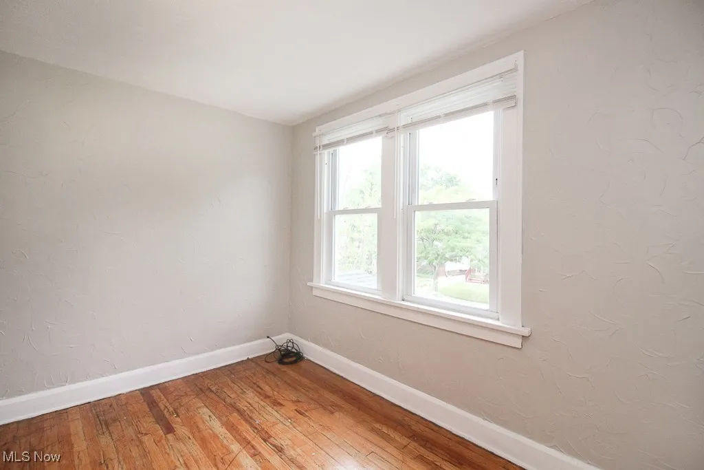 Unfurnished room with light wood-style floors and baseboards