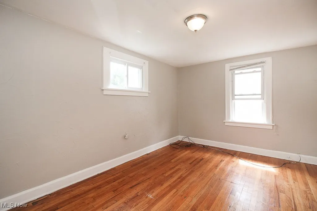 Unfurnished room with wood-type flooring and baseboards