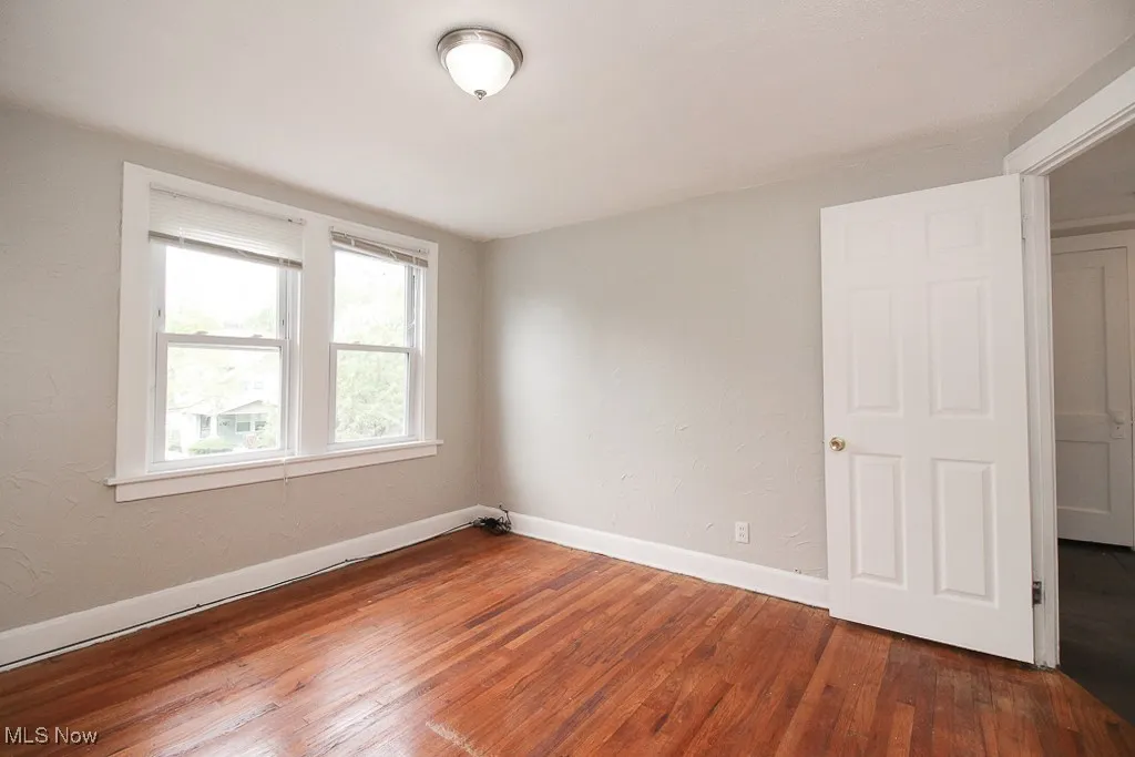 Unfurnished room featuring wood finished floors and baseboards
