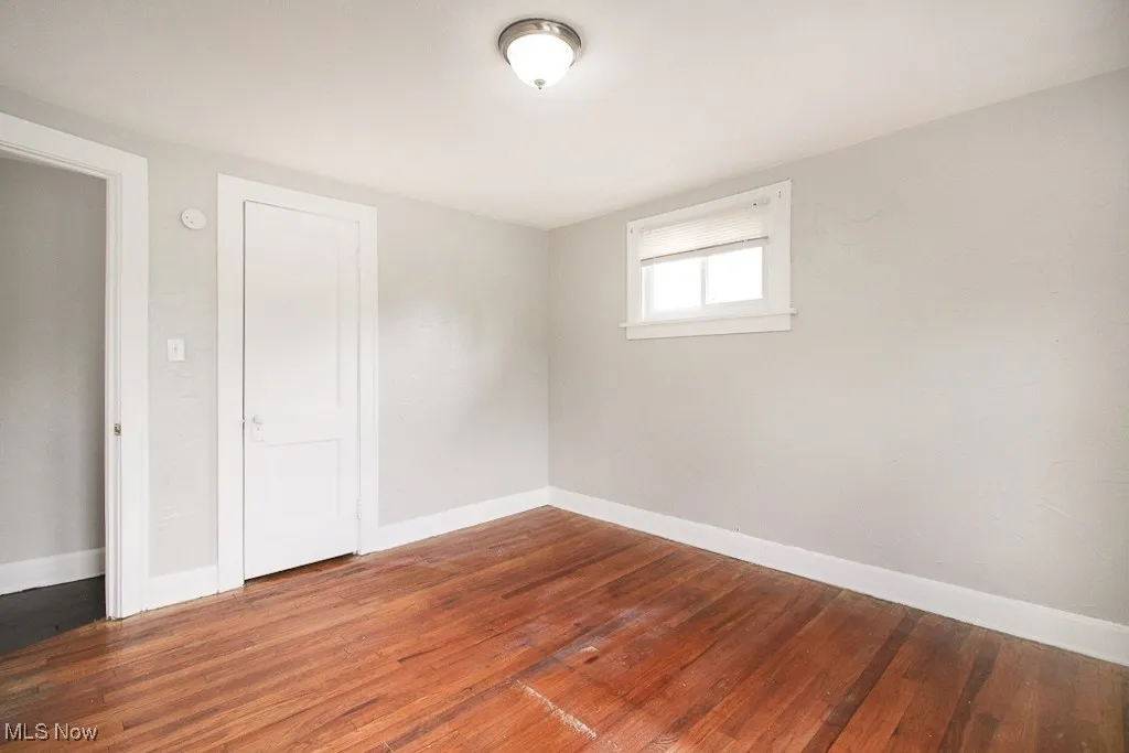 Spare room featuring hardwood / wood-style flooring and baseboards