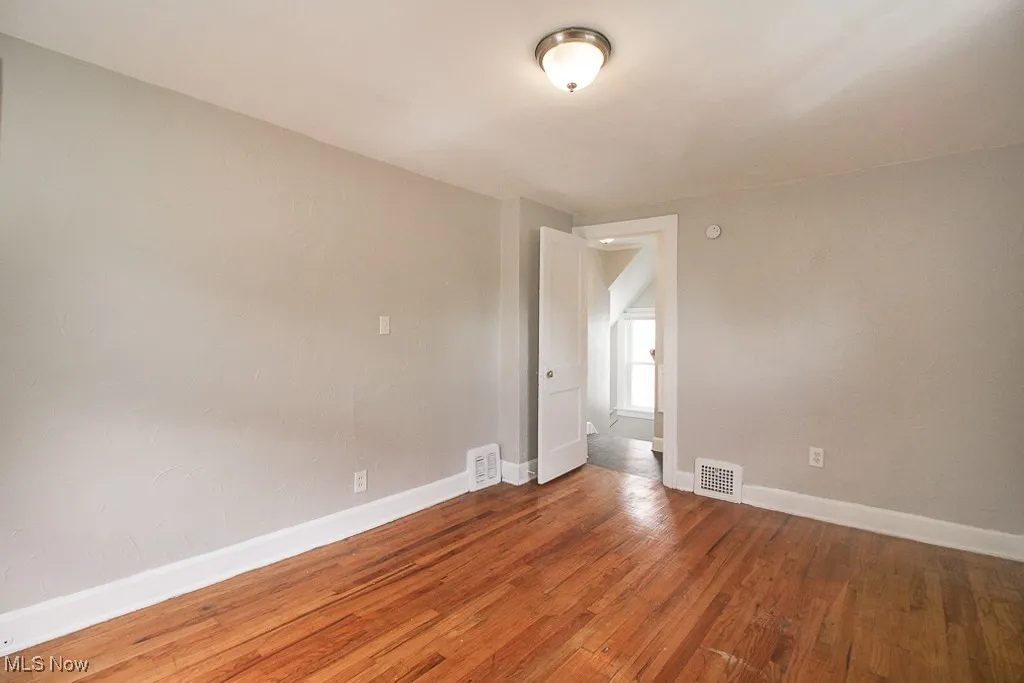 Spare room featuring wood finished floors and baseboards