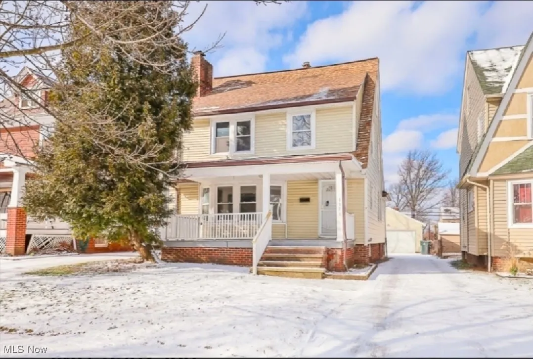 Traditional style home with a porch, an outdoor structure, a chimney, and a detached garage