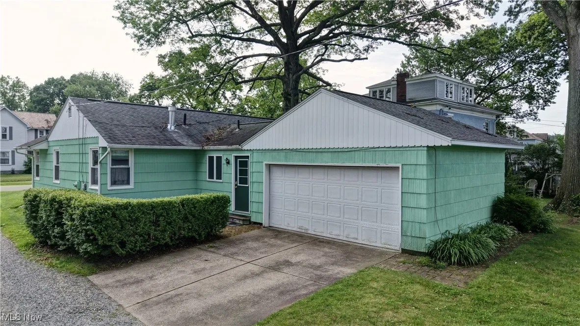 Ranch-style home with roof with shingles and an attached garage