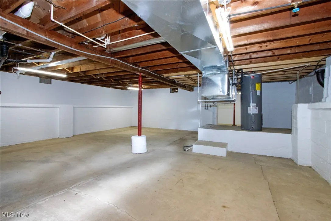 Unfinished below grade area featuring water heater