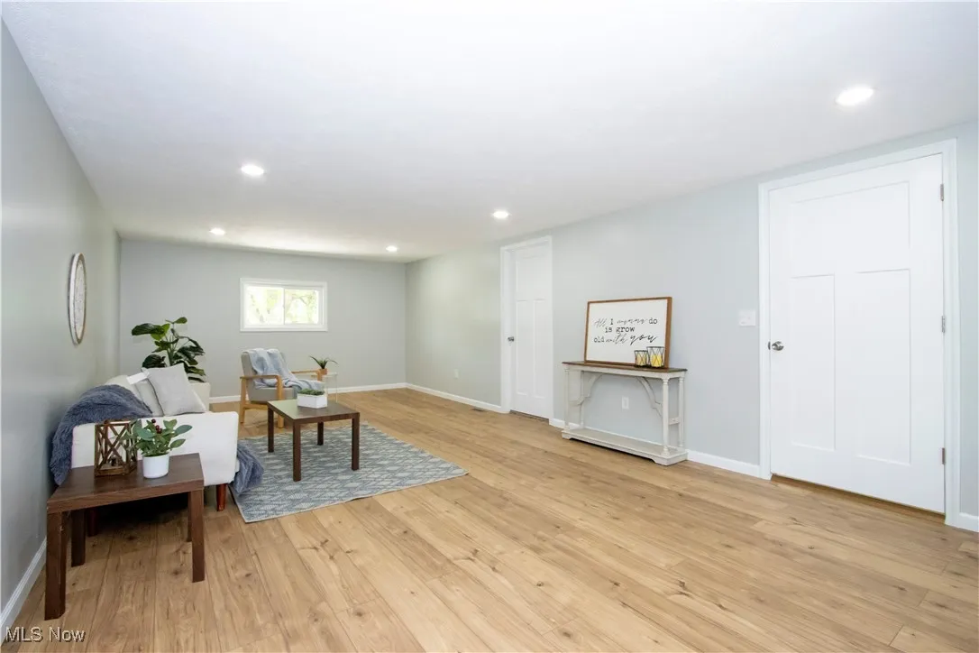 Sitting room with light wood-type flooring and recessed lighting