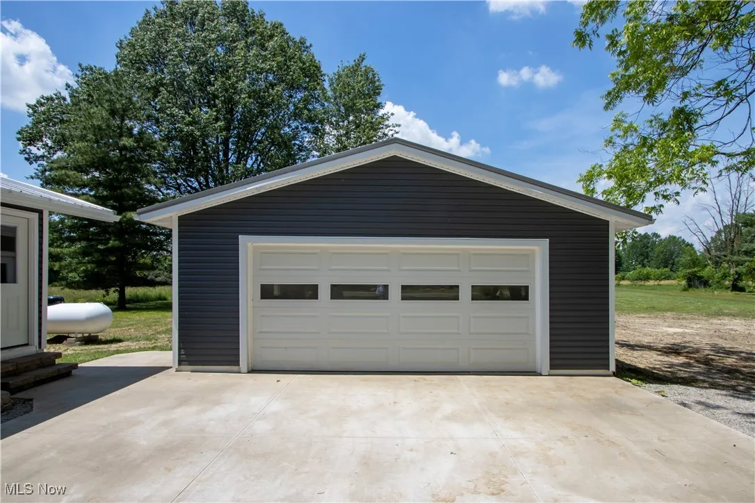 Detached garage featuring concrete driveway
