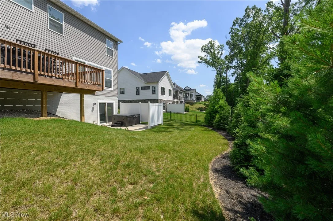 View of yard featuring a hot tub, a wooden deck, and a residential view