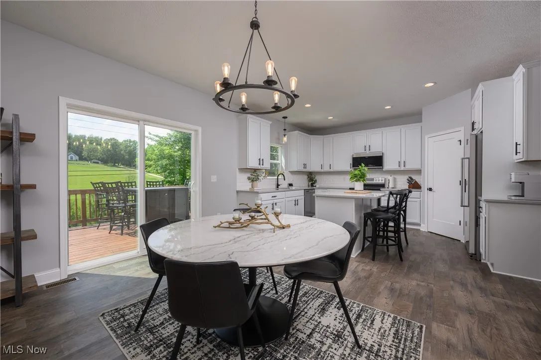 Dining space with a chandelier, dark wood-style flooring, and recessed lighting