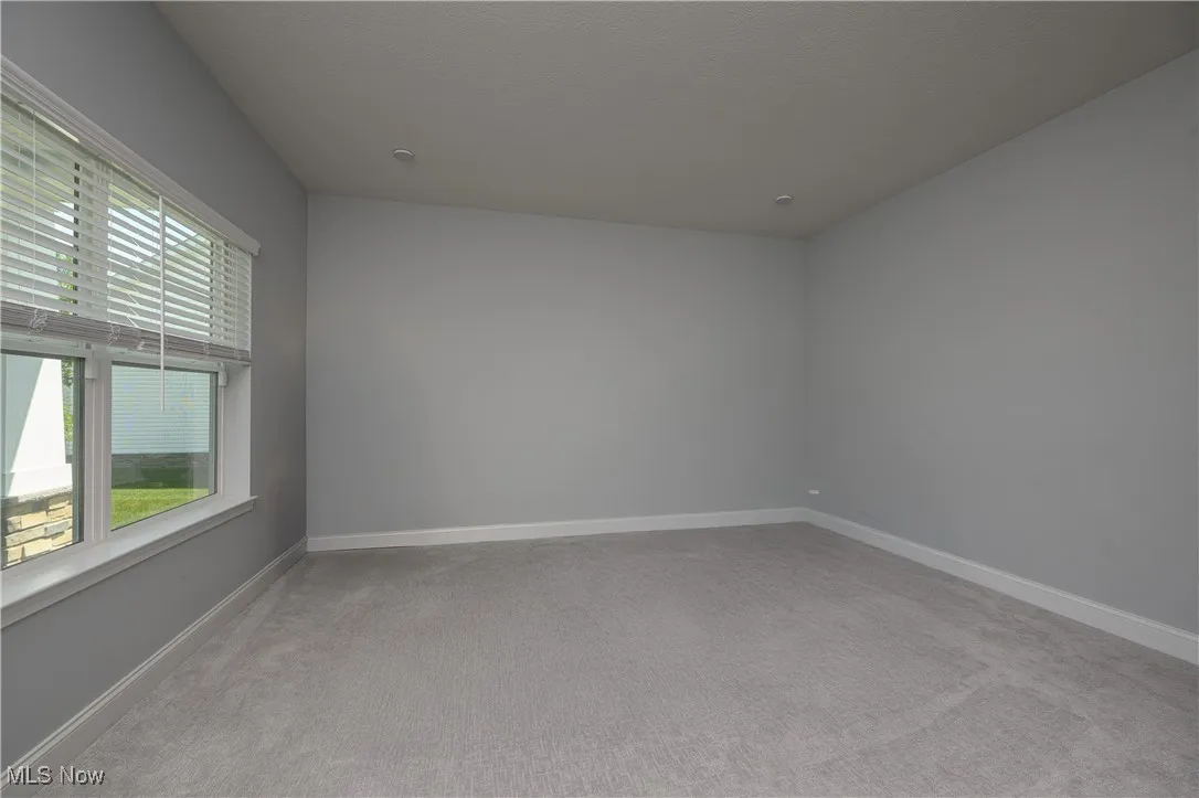 Carpeted empty room with baseboards