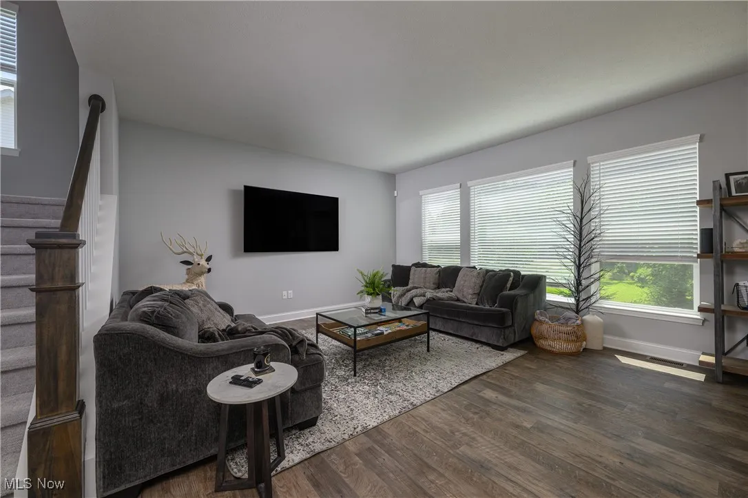Living area with dark wood finished floors and stairway