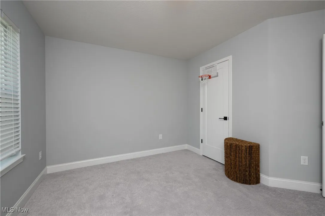 Unfurnished bedroom with carpet flooring and baseboards