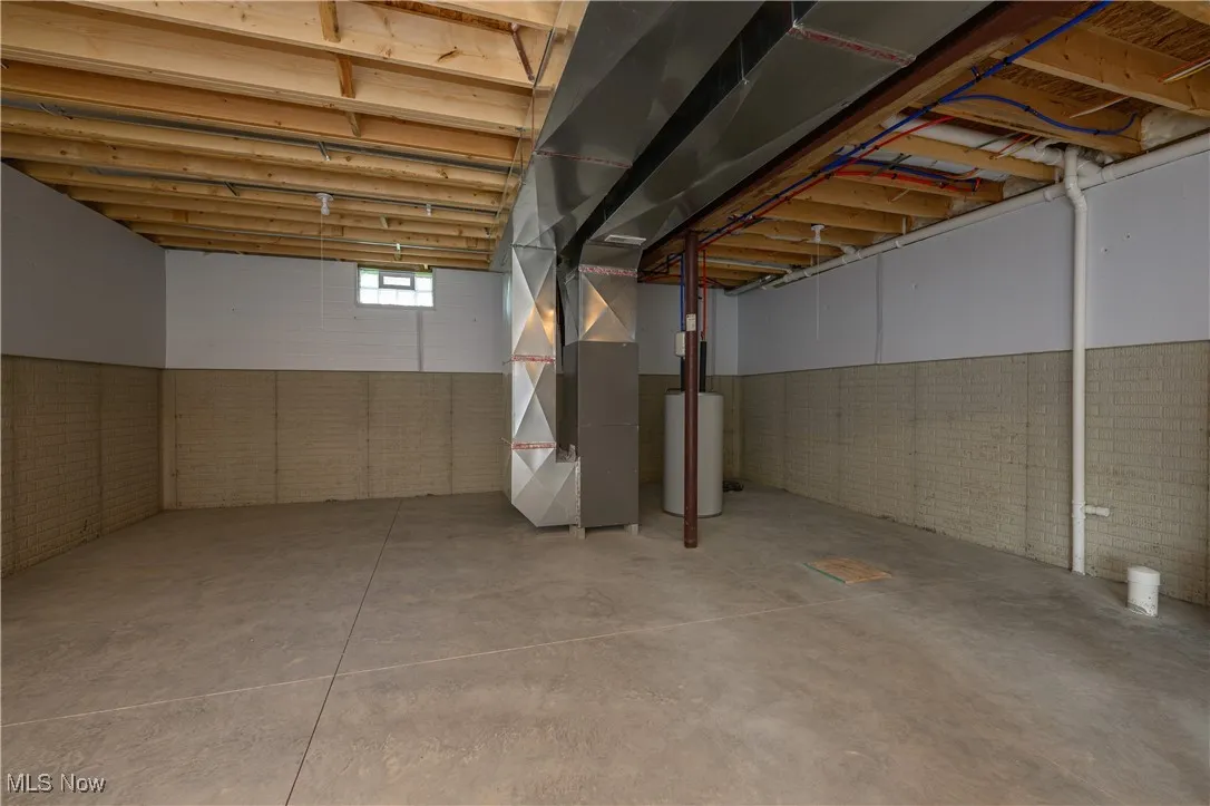 Below grade area with brick wall and heating unit