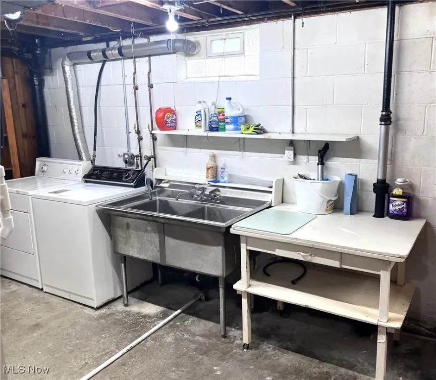 Unfinished basement with washing machine and clothes dryer and a sink