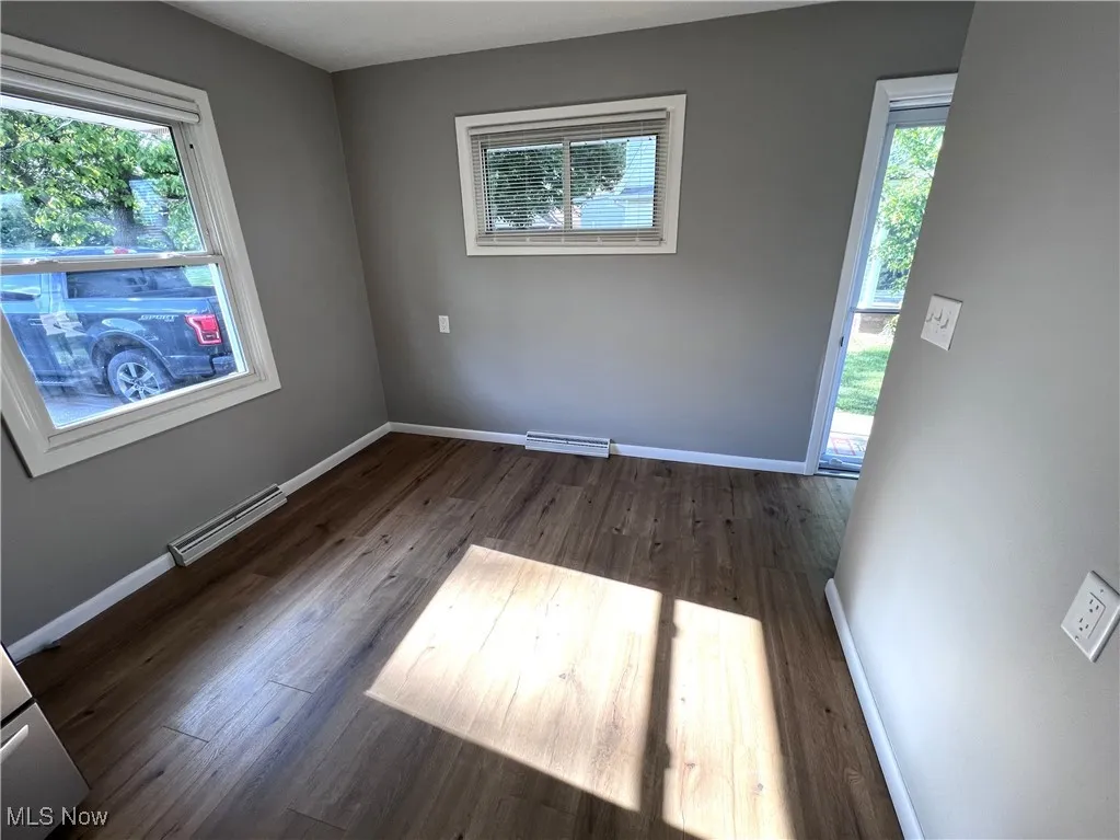 Spare room with healthy amount of natural light and wood finished floors