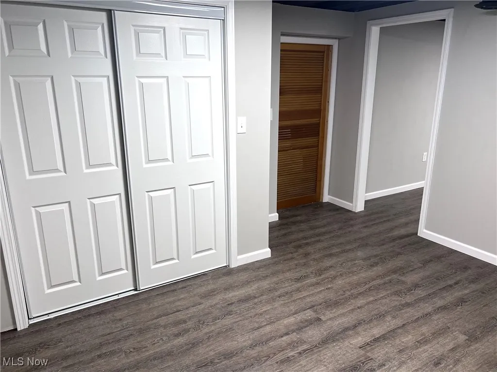 LL bedroom 4 with dark wood-type flooring and a closet