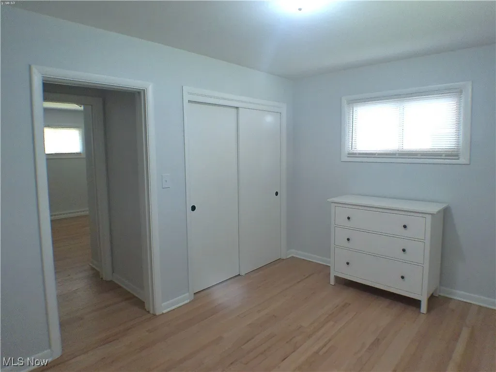 Primary bedroom featuring refinished Oak wood flooring and a closet