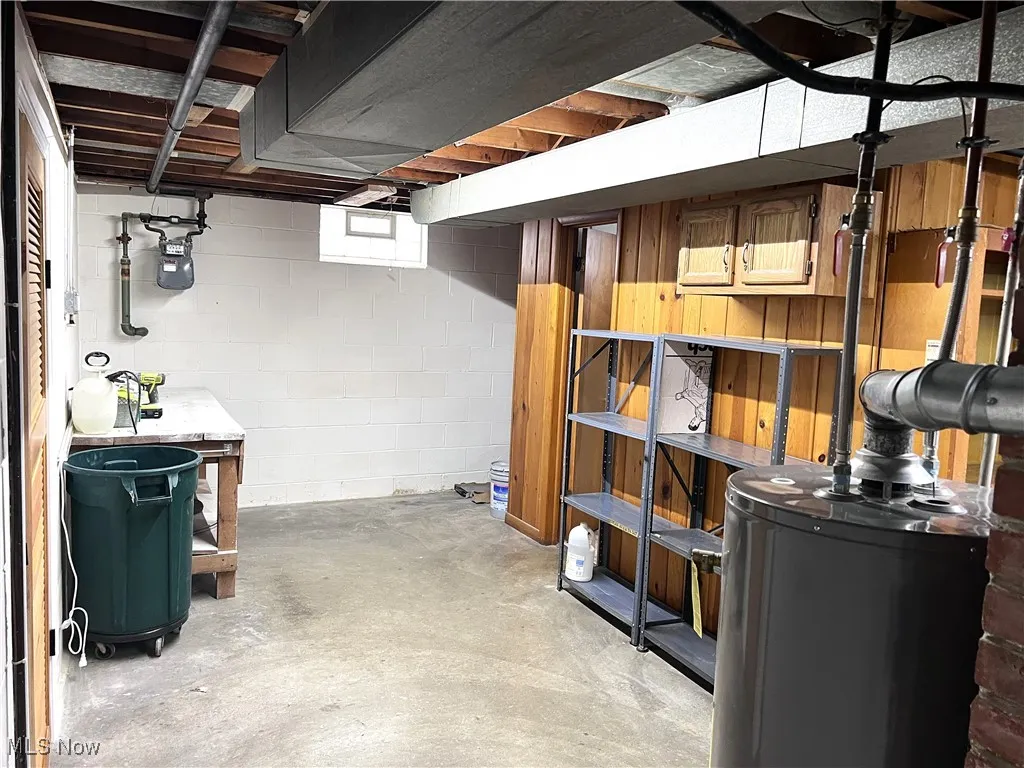 Below grade area with water heater and concrete block wall