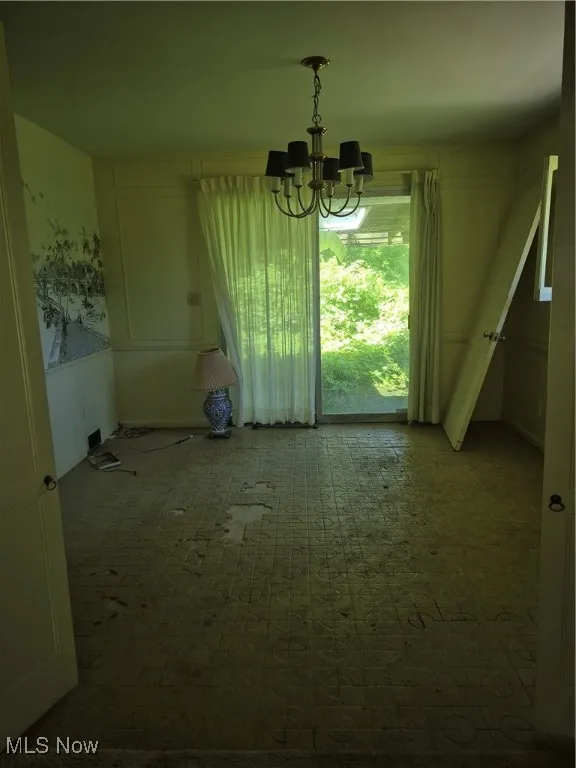 Unfurnished dining area with a chandelier